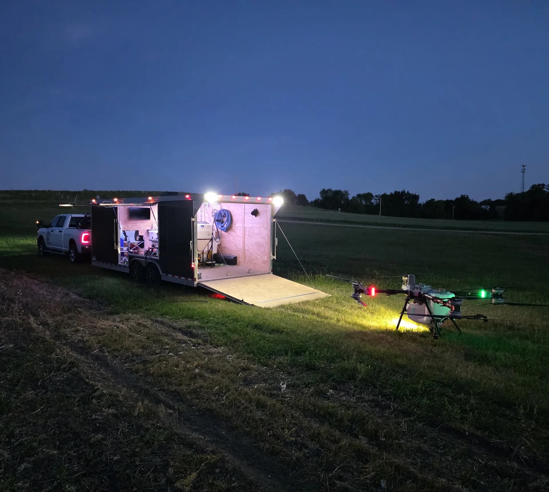 Illuminated Wisconsin Aerial agriculture drone and field-support trailer at night